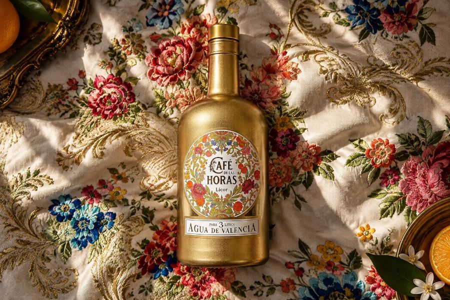 Botella dorada del Licor Café de Las Horas sobre tela de brocado